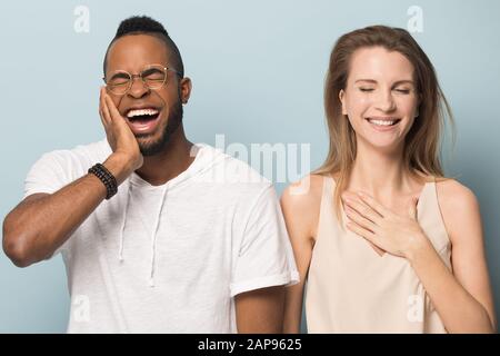 Happy multiracial couple laugh in studio together Stock Photo