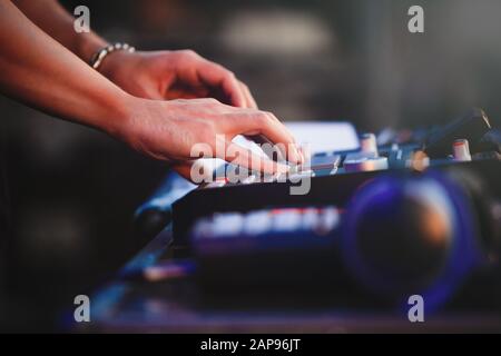 Dj plays beats on drum machine.Hip hop disc jockey playing on concert stage with professional midi controller device.Pro audio equipment on night club Stock Photo