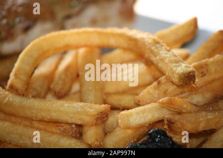 fresh potato string or straight cut french fries oven baked or deep fried as the perfect side dish at any restaurant for dine in or take out orders Stock Photo