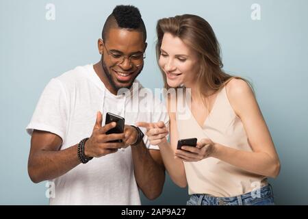Smiling diverse people using cellphones in studio together Stock Photo