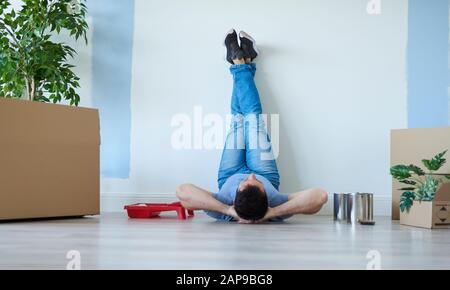 Rear view of man catching a break during moving house Stock Photo
