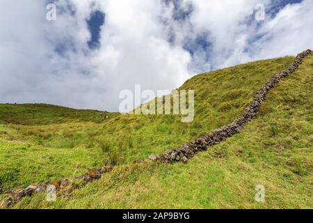 A man made rock wall on the hilly pastures on Pico island in the Azores, Portugal. Stock Photo