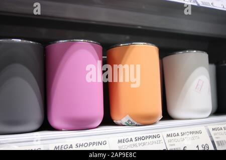 colored glasses or containers of various household items for any domestic use placed on a shelf in a shop or shelf in the house in italy Stock Photo