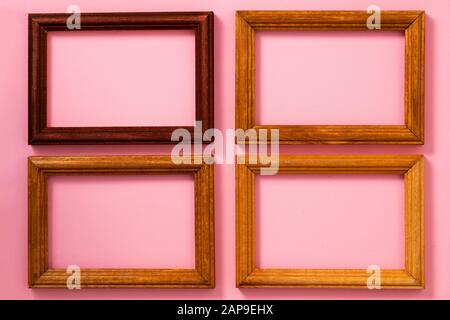 Four wooden picture frames with empty space on the paper the pink background, top view Stock Photo