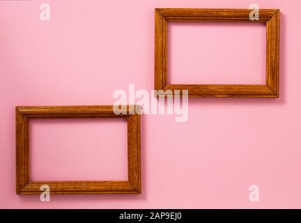 Two wooden photo frames on different levels on paper pink background, top view. Copy space Stock Photo