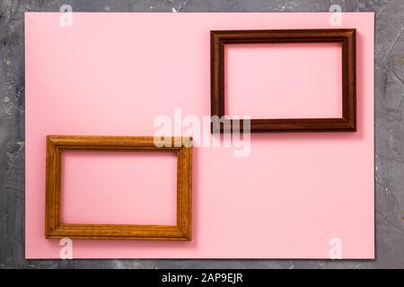 Creative space, two wooden photo frames on pink paper background on grey wood texture Stock Photo