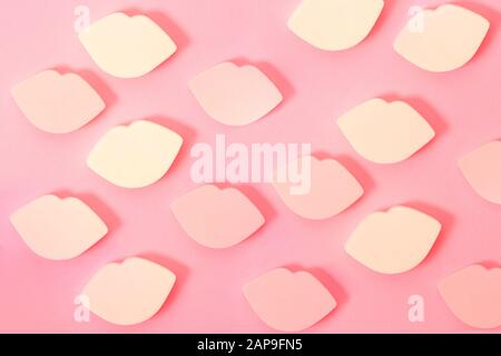 Closeup beautiful pink background with lots of colorful makeup sponges in the shape of lips Stock Photo