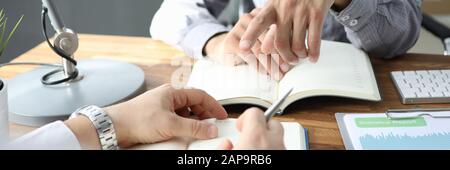 Male interpreter businessman hand pointing on diary Stock Photo