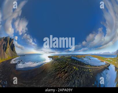 Epic aerial drone view flying over landscape of the black sand beach in Stokksnes on a sunny day. Vestrahorn mountain in the background. Fisheye disto Stock Photo