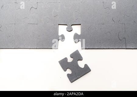 A piece of a puzzle is missing, trying to solve it. Puzzle on background Stock Photo