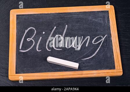 The word education is written with chalk on a blackboard Stock Photo