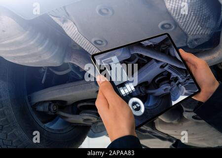 Serviceman repairing a car using augmented reality application Stock ...