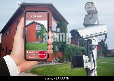 Hand with phone. On the screen interface of remote control surveillance camera Stock Photo