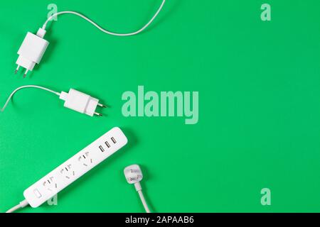 White extension cord and cables on light green background Stock Photo