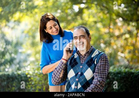 Senior woman sharing media content with her husband using mobile phone Stock Photo