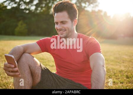 Smiling man using mobile phone after workout Stock Photo