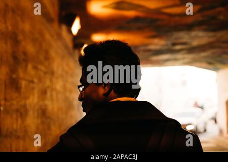 Portrait of a man in the backlight looking back in a tunnel Stock Photo