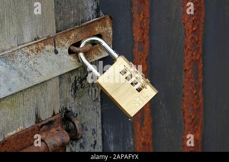 brass padlock on old shed door Stock Photo