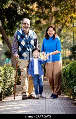 Happy grandparents spending leisure time with little grandson Stock Photo