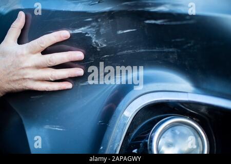 Close Up Of Driver Inspecting Damage To Car After Accident Stock Photo