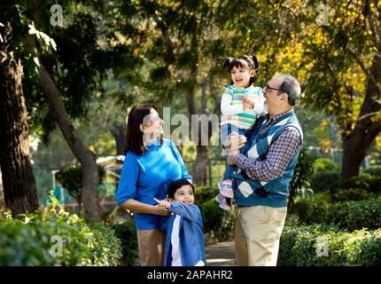 Happy grandparents spending leisure time with grandchildren Stock Photo