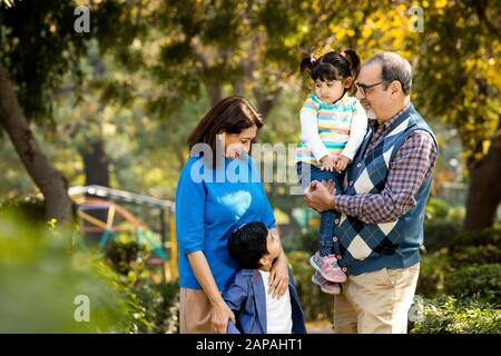 Happy grandparents spending leisure time with grandchildren Stock Photo