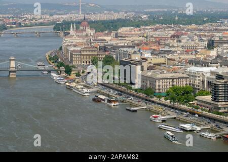 An aerial view of Budapest looking down on the River Danube with river cruise boats and ferries moored in front of the Chain Bridge and parliament. Stock Photo