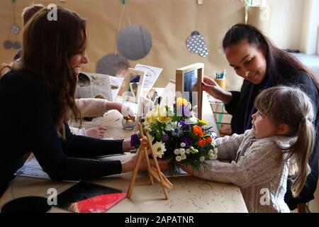 The Duchess of Cambridge receives a posy of flowers from four year-old Erin during a visit to Ely & Caerau Children's Centre in Cardiff. Stock Photo