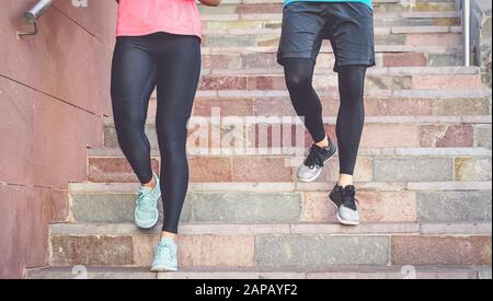 Fit couple doing steps workout session outdoor - Happy friends training running on stairs in city - Health people and sport lifestyle culture concept Stock Photo