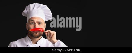 Chef Having Fun Posing With Red Pepper, Black Background, Panorama Stock Photo