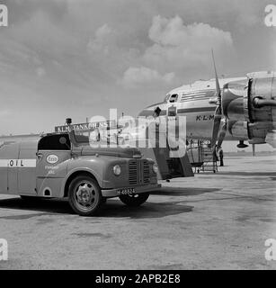 Corporate style and emblems KLM Description: The Douglas DC-4 Edam with the KLM corporate identity and with the Edam logo under the side window of the cockpit at Schiphol Airport in the middle of starting and tankers. Date: August 1951 Location: Noord-Holland, Schiphol Keywords: emblems, logos, tank cars, aircraft Stock Photo