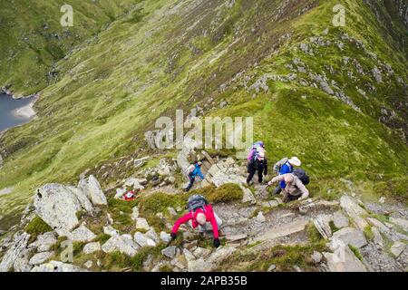 Hikers climbing up Pen yr Helgi Du mountain from Ffynnon Llugwy reservoir in Carneddau mountains of Snowdonia National Park. Ogwen, North Wales, UK Stock Photo