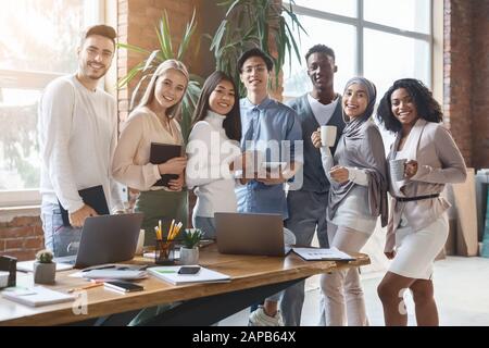 Happy young business team posing in office during working day Stock Photo