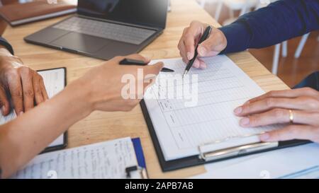 Young students classmates help friend catching up workbook and learning tutoring in a library, education and school concept. Stock Photo