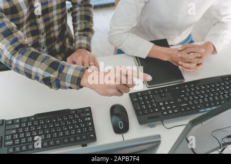 Young startup Programmers Sitting At Desks Working On Computers screen for Developing programming and coding to find solution to problem on New Applic Stock Photo