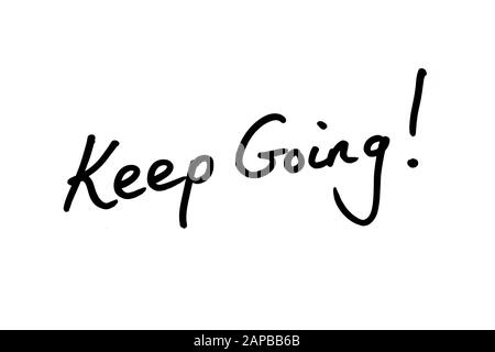 Close-up of a Keep Going! message handwritten on a white background. Stock Photo