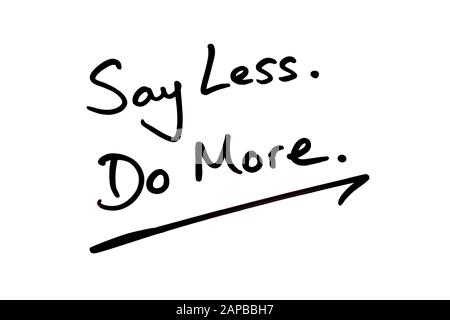 Close-up of a Say Less Do More message handwritten on a white background. Stock Photo