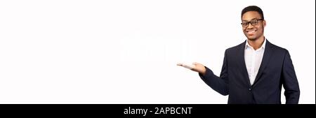 Smiling black man with his palm up over white background Stock Photo