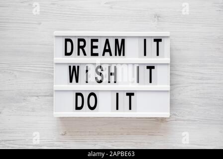 'Dream it, wish it, do it' words on a lightbox on a white wooden background, top view. Overhead, from above, flat lay. Closeup. Stock Photo