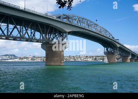 Looking over Waitemata Harbour at downtown Auckland city from the North Shore with the Harbour Bridge in foreground. New Zealand. Stock Photo