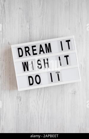 'Dream it, wish it, do it' words on a lightbox on a white wooden background, top view. Overhead, from above, flat lay. Stock Photo