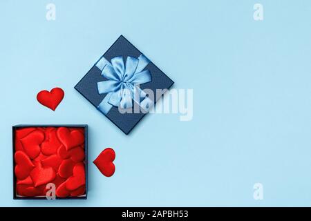 Blue open gift box with hearts on a colored background. The concept of love and Valentine's Day. Stock Photo