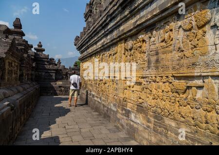 Man walking in the ancient Buddhist temple of Borobudur, in Magelang, Central Java, Indonesia Stock Photo