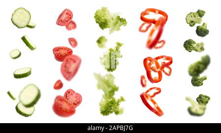 Mixed slices of cucumber, tomato, paprika and others in the air Stock Photo