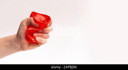 Hand holding squashed cup on white background Stock Photo