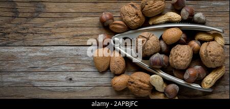 top view of various  dried fruit and nutcracker on old wood Stock Photo