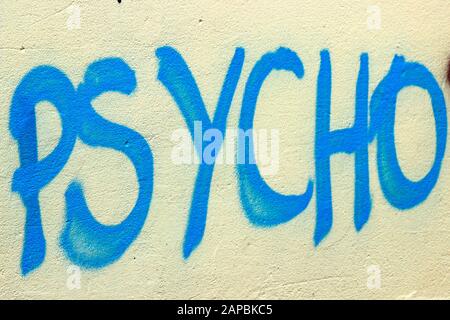 Psycho - blue graffiti text on yellow wall Stock Photo