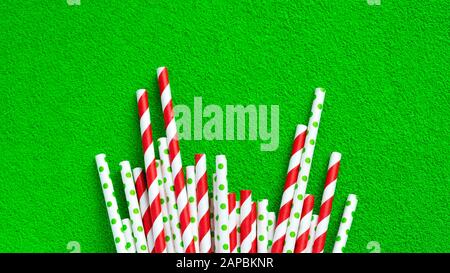 A lot of red tubes for juice on a green background. Stock Photo