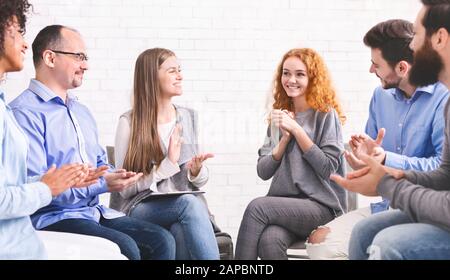 Woman appreciating support of people at group therapy meeting in rehab Stock Photo