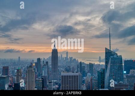 New York skyline from Top of The Rock at sunset with clouds in the sky in the background Stock Photo